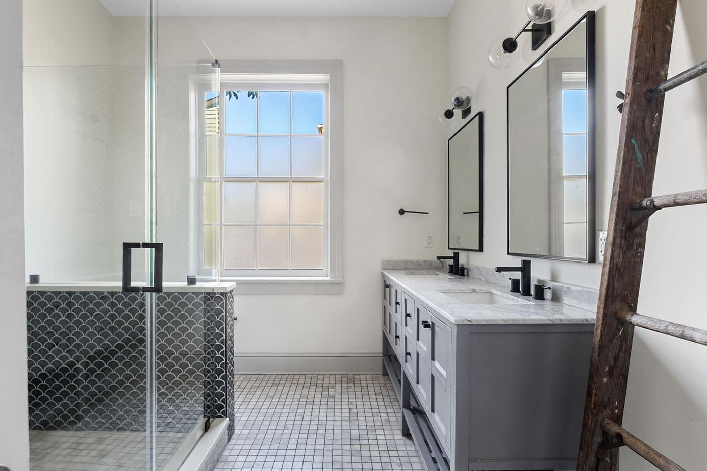 Modern bathroom with a double-sink vanity, twin rectangular mirrors, black fixtures, a glass-enclosed shower, and a wooden ladder by the wall.