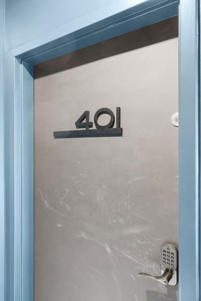 Metal door with the number 401 in bold, a horizontal bar beneath the digits, and a keypad deadbolt on the right side.