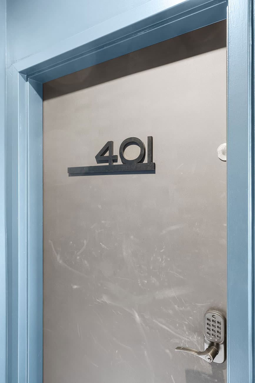 Metal door with the number 401 in bold, a horizontal bar beneath the digits, and a keypad deadbolt on the right side.